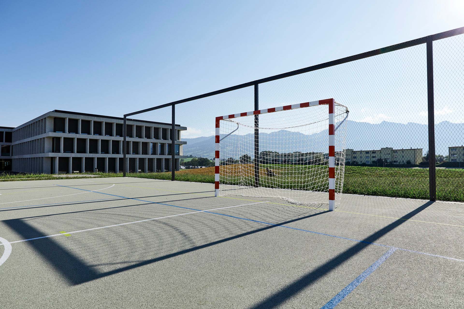 Sports court and goal in front of ball fence